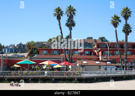 view of santa cruz california from the beach showing a couple relaxing on beach chairs and diners at an outdoor restaurant Stock Photo