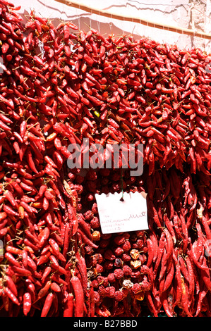 Red chillis hanging for sale outside a vegetable shop in Italy Stock Photo