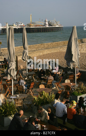 City of Brighton and Hove, England. Visitors in one of the many bars, cafes and restaurants on Brighton beach. Stock Photo