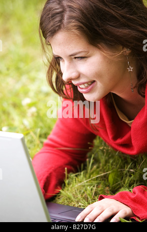 A beautiful student girl working on her laptop outdoor at sunny day Stock Photo