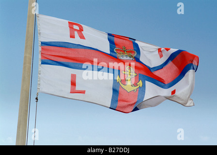 A closeup image of the RNLI flag in Newquay harbor flying in a strong wind shot in Cornwall England Stock Photo