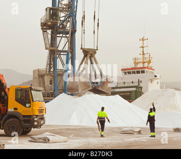 Harbour crane lifting phosphates into ship in Malaga port Spain Stock Photo
