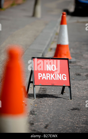 A small No Parking sign between two orange traffic cones tries to stop motorists parking. Picture by Jim Holden. Stock Photo
