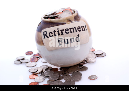 Retirement fund jar filled to overflowing with multiple types of coins Stock Photo