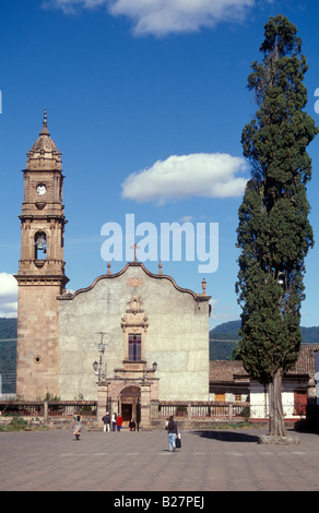 Church and cypress tree in the village of Santa Clara del Cobre near Lake Patzcuaro, Michoacan, Mexico Stock Photo