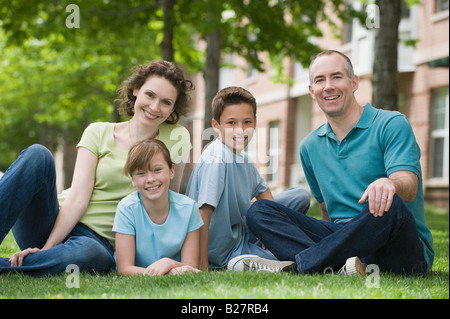 Family with two children sitting on grass Stock Photo