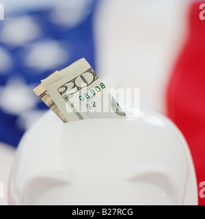Twenty dollar bill in piggy bank slot Stock Photo