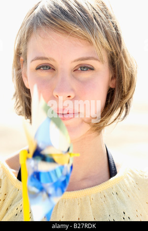 Woman blowing on pinwheel Stock Photo
