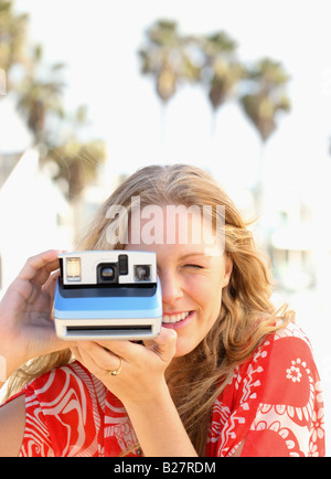 Woman taking photograph with instant camera Stock Photo