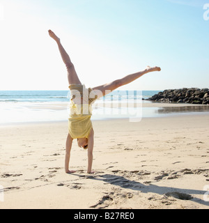 Woman doing cartwheel on beach Stock Photo