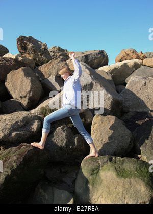 Woman climbing on rocks Stock Photo