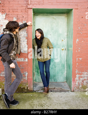 Couple talking in urban doorway Stock Photo