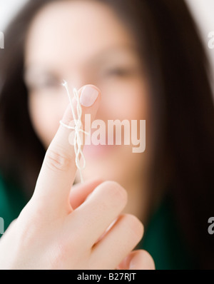 Woman with string tied around finger Stock Photo