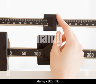 Close up of woman’s hand on scale Stock Photo