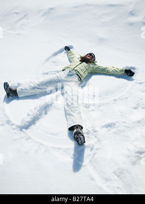 Woman making snow angel Stock Photo