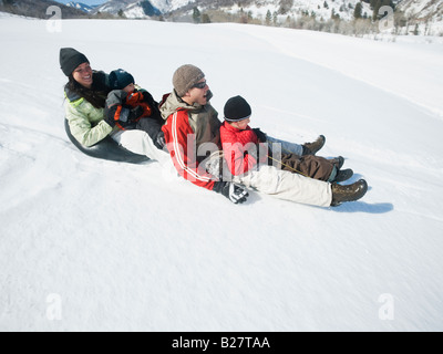 Family riding on sled Stock Photo