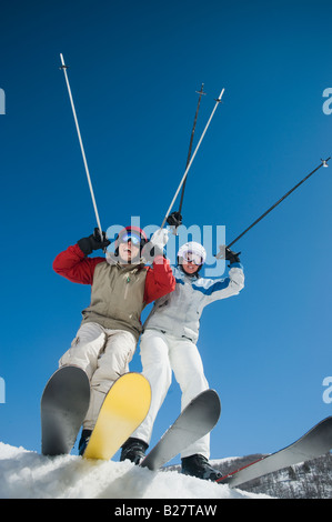 Couple with arms raised on skis Stock Photo