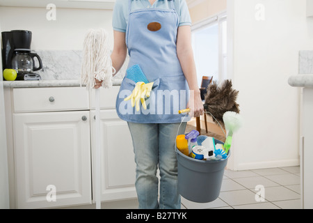 Woman holding mop and cleaning supplies Stock Photo