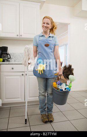 Woman holding mop and cleaning supplies Stock Photo