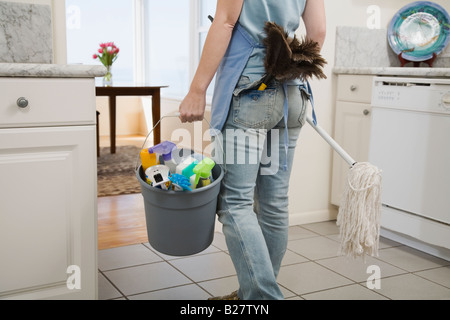 Woman holding mop and cleaning supplies Stock Photo