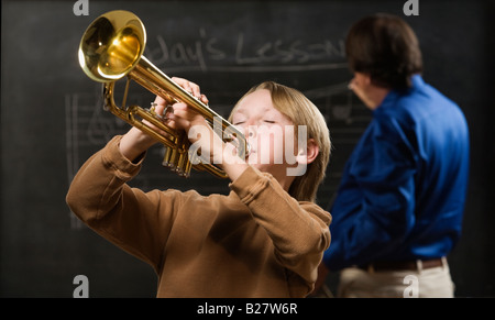 Boy playing trumpet in classroom Stock Photo