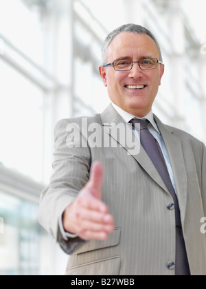 Businessman extending hand to shake Stock Photo