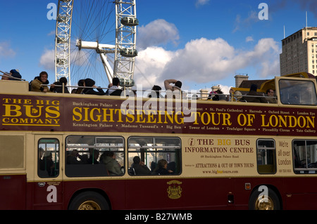 Tourists exploring London on a double decker bus driving across Westminster bridge with London Eye in the background.