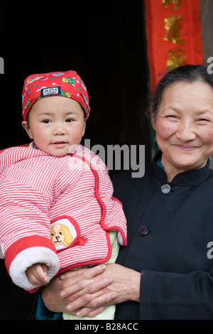 Woman carries granddaughter in Fuli Xingping China has a one child family planning policy to limit population Stock Photo