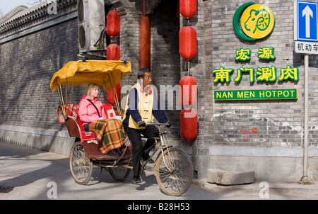 Western tourist in a rickshaw Hutongs area Beijing China Stock Photo