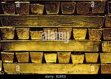 Gold bars ingots bullion pure raw closely stacked in a secure precious metal bullion room safe Stock Photo