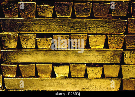 Gold bars ingots pure raw closely stacked in a secure precious metal bullion room safe Stock Photo