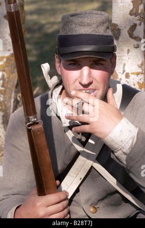 A confederate soldier smoking around a campfire at a civil war reenactment Stock Photo