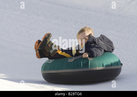 Young boy enjoys a tube ride Whistler British Columbia Canada Stock Photo