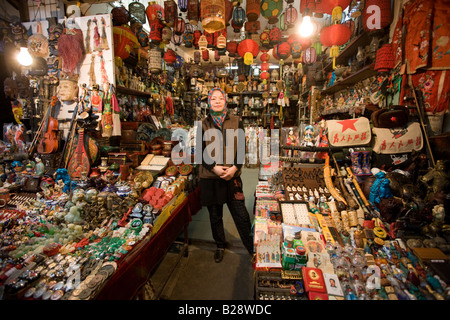 Chinese woman of Hui Minority Group selling souvenirs at market stall in Moslem district of Xian China Stock Photo