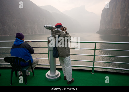 Tourists take photographs from the deck of a Victoria Line Cruise Ship Yangtze River China Stock Photo