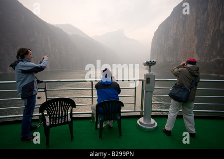 Tourists take photographs from the deck of a Victoria Line Cruise Ship Yangtze River China Stock Photo