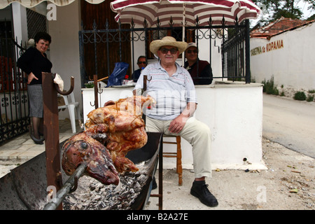 Greece Thessaly Lefokastro a little fishing village on the Pagasetic Gulf A man grilling a lamb in the street Stock Photo