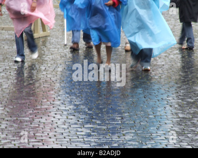 tourists people wearing waterproof coat capes in rain Stock Photo