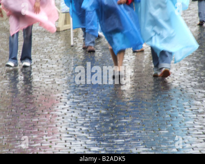 tourists people wearing waterproof coat capes in rain Stock Photo