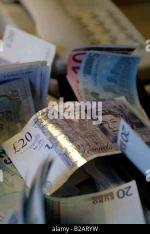 scattered paper sterling and euro notes on top of telephone Stock Photo