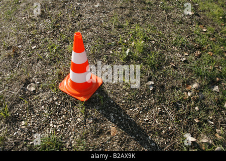 one single traffic cone in field on country lane Stock Photo