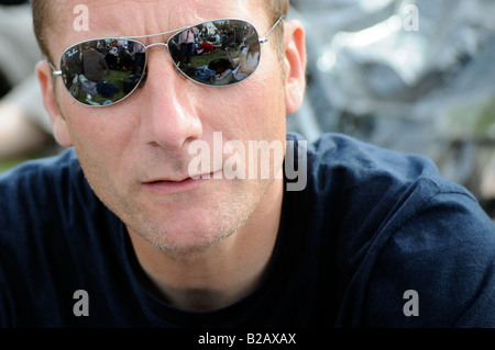 Royalty free photograph of man wearing shade sunglasses and looking at the camera at a music festival in London UK Stock Photo