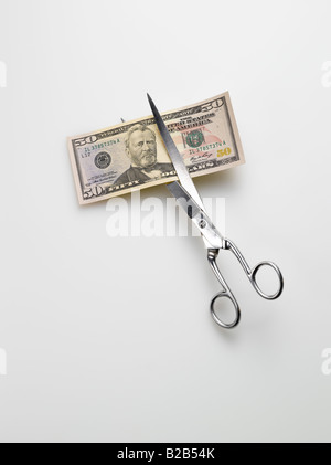 scissors cutting American 5 five dollar bill money on white background Stock Photo
