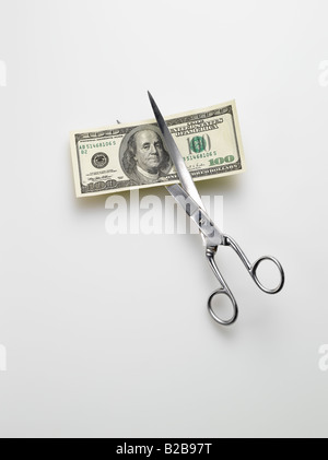 scissors cutting American 100 hundred dollar bill money on white background Stock Photo