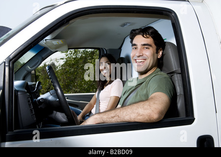 Young couple sitting in moving truck Stock Photo