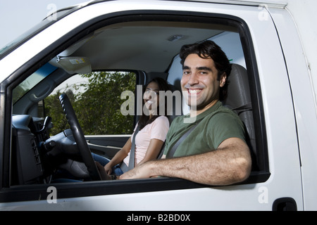 Young couple sitting in moving truck Stock Photo