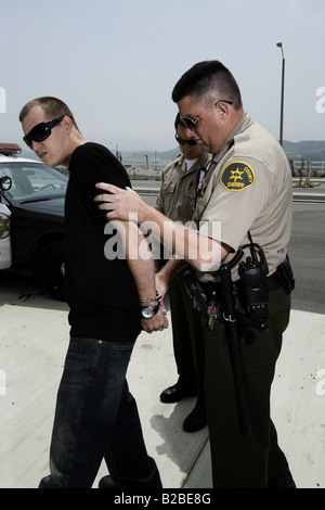 Police officer escorting man in handcuffs Stock Photo - Alamy