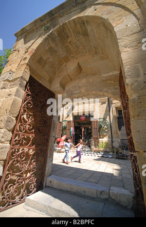 NORTH CYPRUS. Children running down a street in North Nicosia, seen through the gateway to the Selimiye Mosque. 2008. Stock Photo