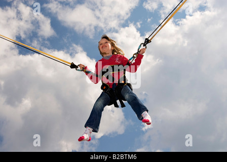 Small, 5-year-old girl jumping on a bungee trampoline Stock Photo