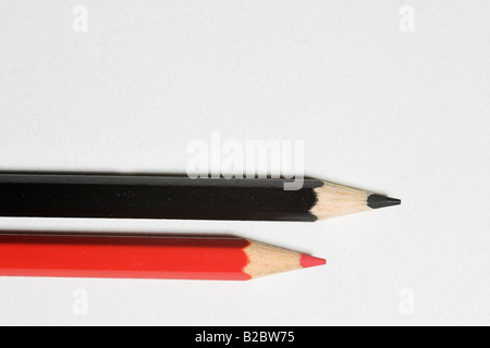 Black and red pencil lying on white cardboard Stock Photo